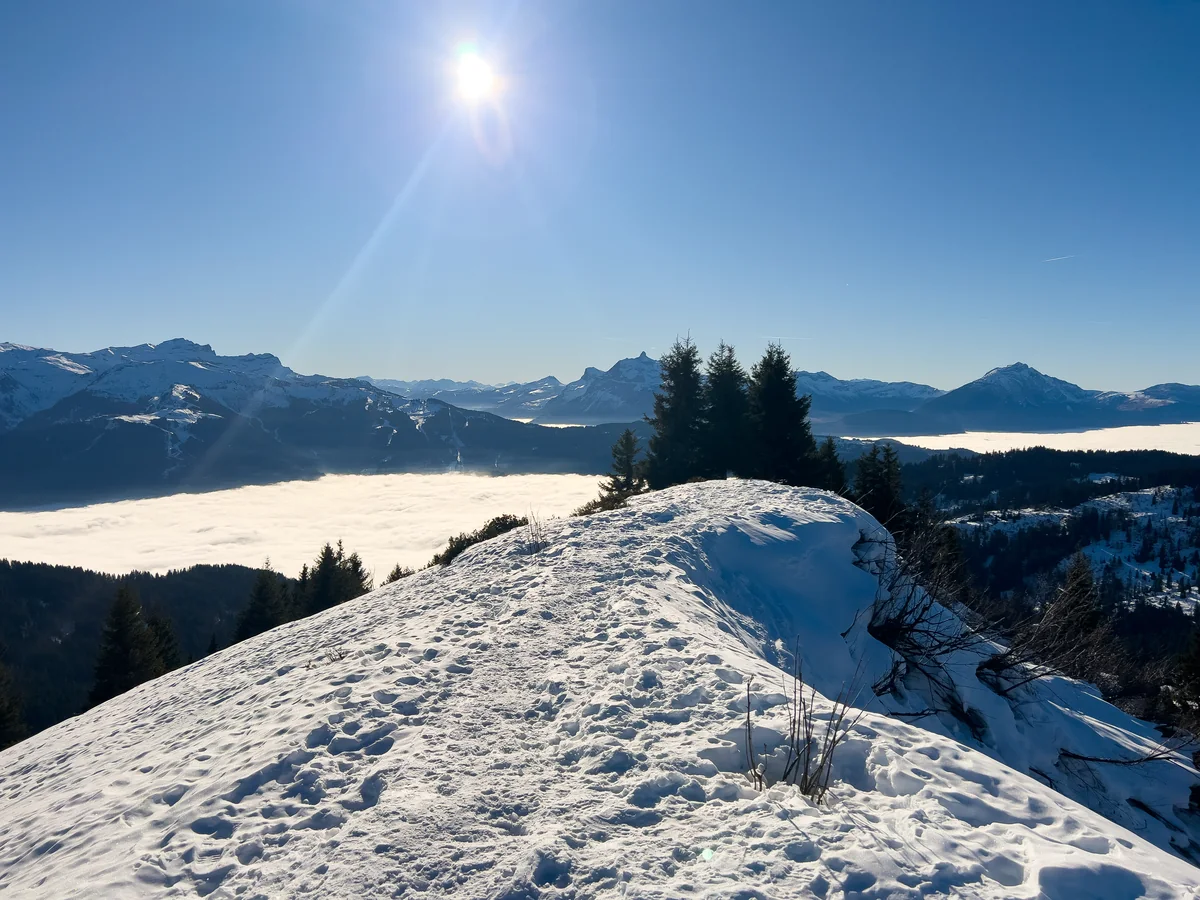 Crête enneigée au-dessus d'une mer de nuages au sommet du télésiège de Ranfoilly, Les Gets, sous le soleil d'hiver