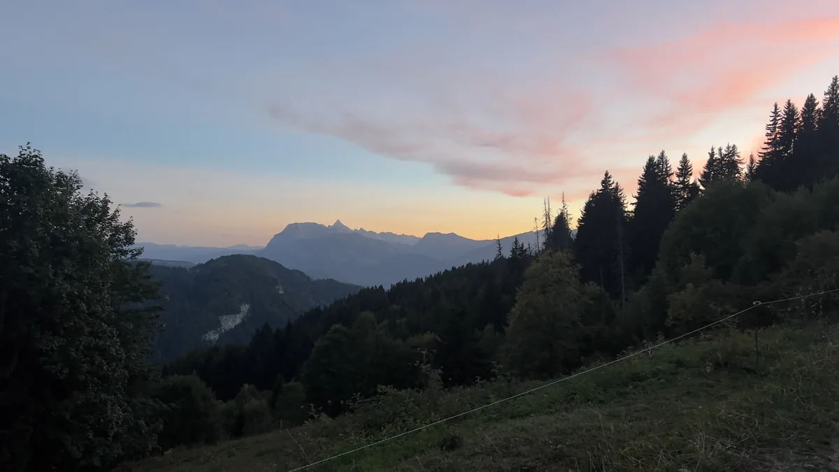 Sunrise over the mountains near Les Gets, pink clouds above forested valleys