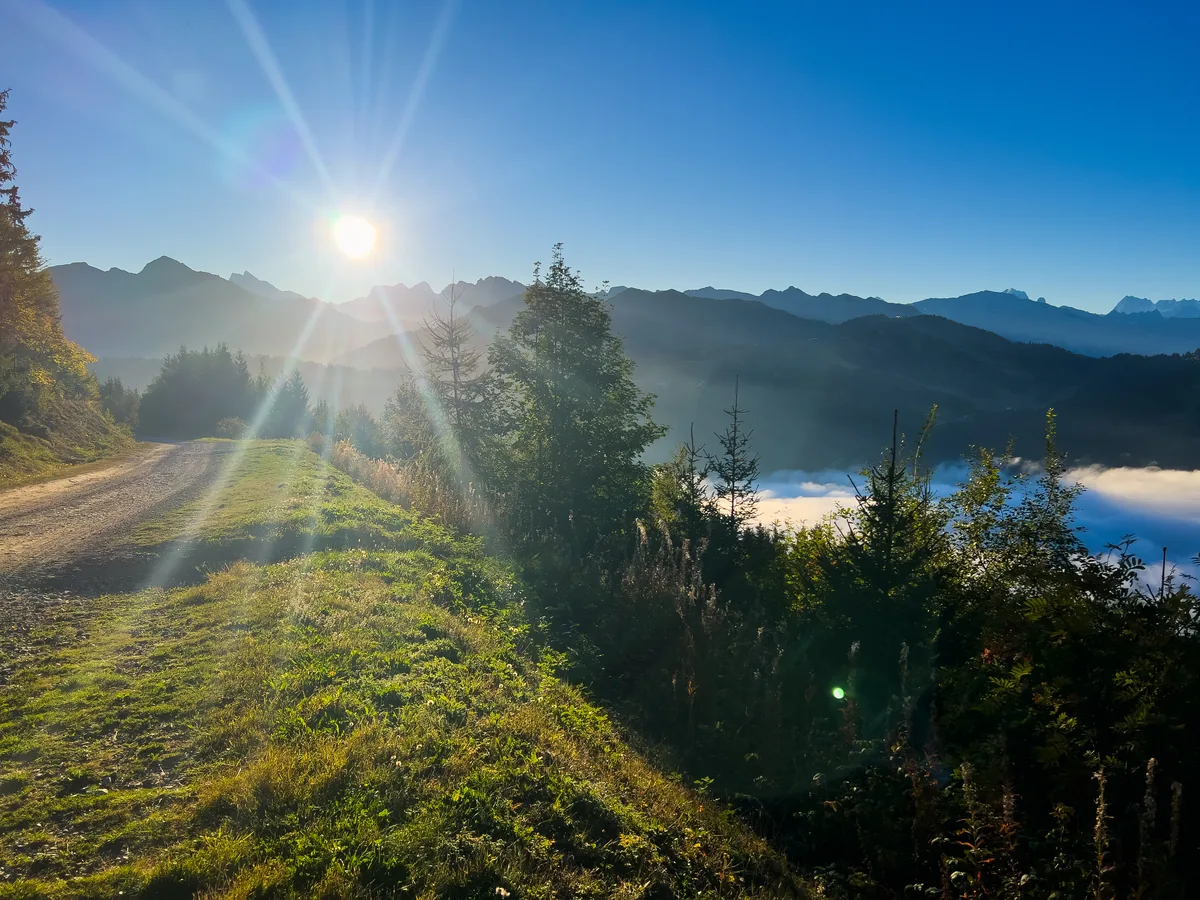 Morning sun over a mountain track above a sea of cloud near Les Gets