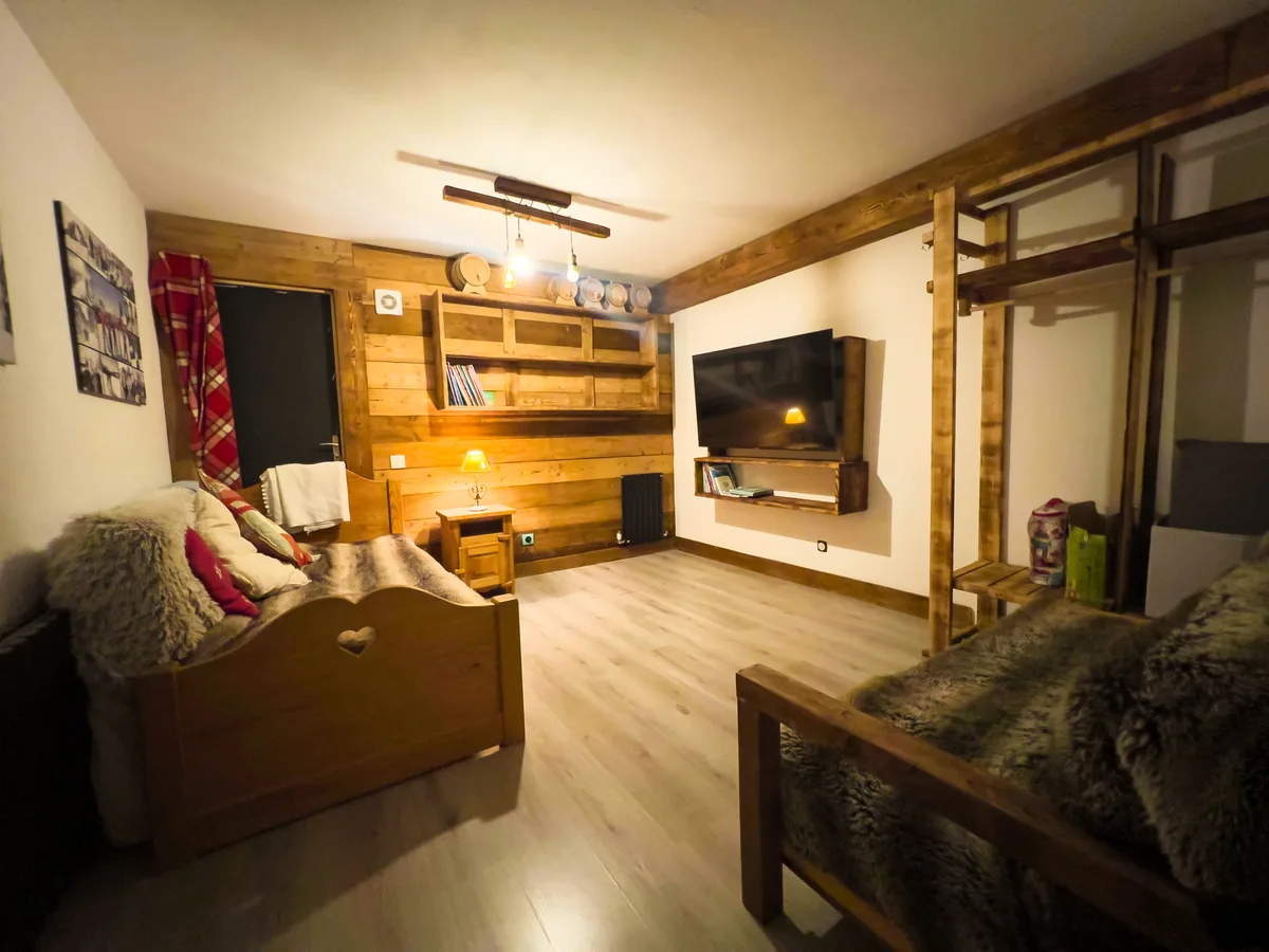 Ground-floor TV and games room with a big screen, two daybeds and wood-panelled walls